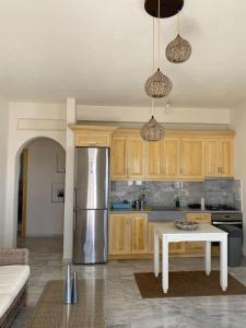 a kitchen with a stainless steel refrigerator and a table at Nefeli Residence @ Astypalaia island in Analipsi