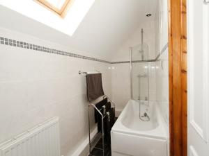 a white bathroom with a sink and a bath tub at Mill House in North Somercotes