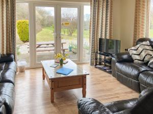 a living room with a couch and a coffee table at Green Valley Retreat in Holsworthy