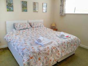 1 dormitorio con 1 cama con toallas en Ivy Cottage en Mountblairy