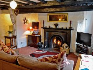 a living room with a fireplace and a couch at Barker Knott Farm Cottage in Bowness-on-Windermere