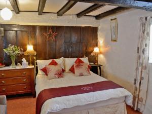 a bedroom with a bed and a wooden wall at Barker Knott Farm Cottage in Bowness-on-Windermere