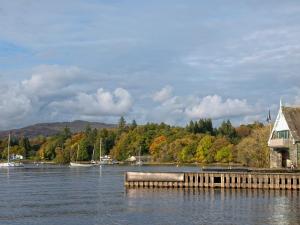 a body of water with a dock and a house at Barker Knott Farm Cottage in Bowness-on-Windermere