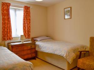 a bedroom with two beds and a window at Red Lion Cottage in Chatteris