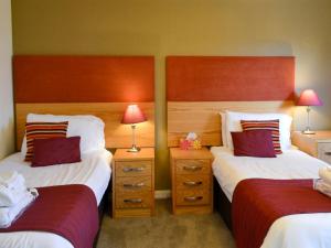 a hotel room with two beds and two lamps at Holly Lodge in Aviemore