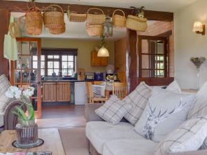 a living room with a couch and a kitchen at The Warren in Wellesbourne Hastings