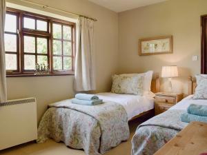 een slaapkamer met 2 bedden en een raam bij The Warren in Wellesbourne Hastings