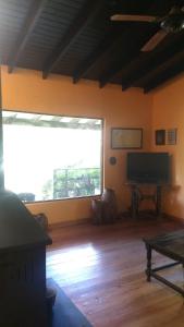 a living room with a large window and a flat screen tv at Flamante casa en Delta de Tigre in Buenos Aires