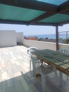 a wooden table and chairs on a patio with an umbrella at Denize sıfır 2 yatak odalı daire D 8 in Tekirdag