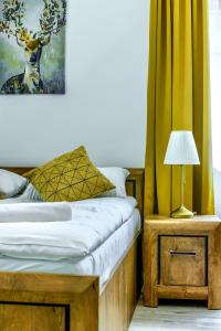 ein Schlafzimmer mit einem Bett und einem Tisch mit einer Lampe in der Unterkunft Dom Kawalera in Kadyny
