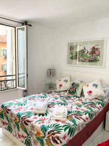 a bedroom with a large bed with a floral bedspread at Cannes 3 min from Congress Palace, Croisette, Beaches in Cannes