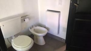 a white bathroom with a toilet and a sink at Flamante casa en Delta de Tigre in Buenos Aires