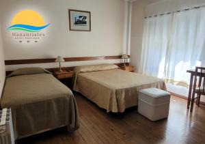 a hotel room with two beds and a sign on the wall at Manantiales Hotel Boutique in Victoria