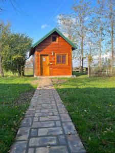 einen Backsteinweg, der zu einem kleinen Holzhaus führt in der Unterkunft Salaš Gnijezdo in Bačka Palanka