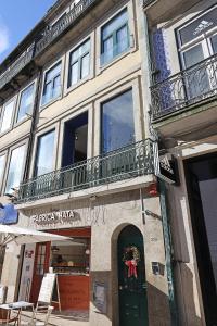 un edificio con una puerta verde y un balcón en FLH Porto Downtown GuestHouse, en Oporto