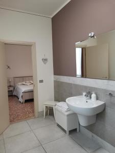 baño con lavabo, espejo y cama en Il Colibrì Bed&Breakfast en Leno