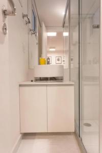 cocina blanca con ducha y microondas en Studio Aconchegante! 1116, en São Paulo