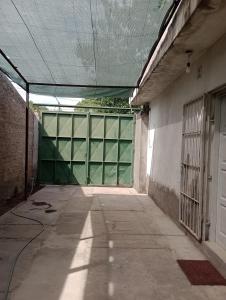 un pasillo vacío con una gran puerta verde de garaje en Alojamiento Comodoro en San Rafael