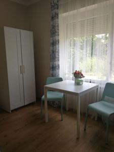 a room with a table and two chairs and a window at CASA MINI 5 in Pécs