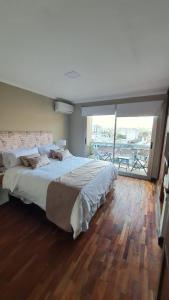 a bedroom with a large bed and a large window at Departamento Caseros in Salta