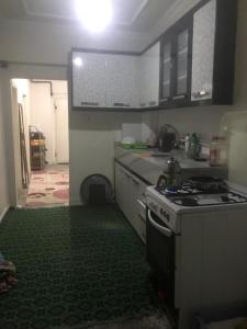 een keuken met een fornuis en een groene vloer bij House in Kayapınar