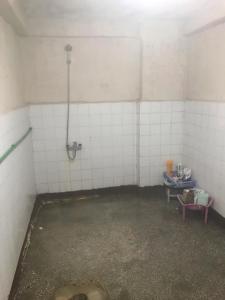 an empty bathroom with white tiled walls and a puddle at House in Kayapınar