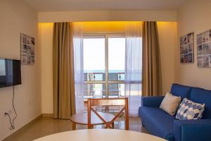 a living room with a blue couch and a window at Hotel Boutique TAO Caleta Mar in Corralejo