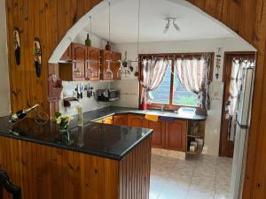 a kitchen with wooden cabinets and a black counter top at Barrio Country in Piriápolis