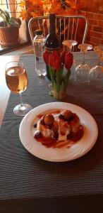 a plate of food on a table with flowers and wine at Nova Montan Azuga in Azuga