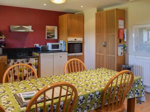 a kitchen with a table and chairs and a kitchen with a microwave at The Byre in Westerdale