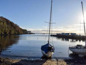 due barche sedute sulla riva di un corpo d'acqua di Bankhead Farm Cottage a Crossgates