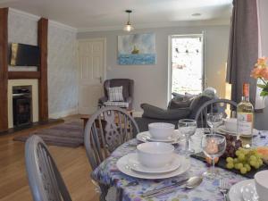 a dining room with a table and chairs and a living room at Conway Cottage in Pembroke