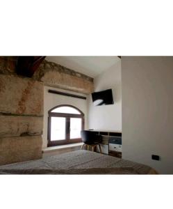 1 dormitorio con cama y ventana en ATTIKO 53 Boutique Rooms, en Verona