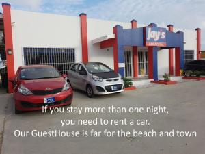 a car dealership with two cars parked in a parking lot at Varadero Marina Airport Guests Rooms in Oranjestad