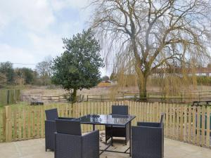 a patio with a table and chairs and a fence at No, 1 Ash Cottage in Quatt
