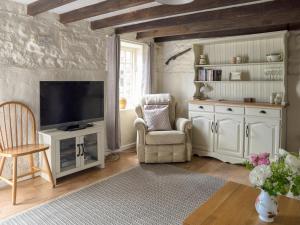 a living room with a tv and a chair at Nightingale Cottage - Ukc1570 in Crich