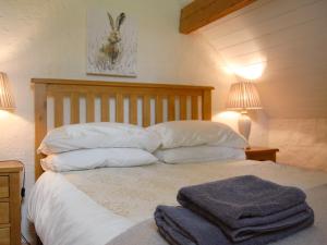 1 cama con sábanas y almohadas blancas y 2 lámparas en Nightingale Cottage - Ukc1570, en Crich