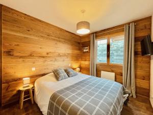 1 dormitorio con 1 cama en una pared de madera en Le Chalet Cerdagne **** Vue Panoramique, en Font-Romeu-Odeillo-Via