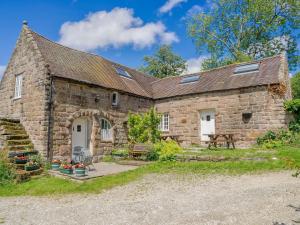 una antigua casa de piedra con un patio frente a ella en Nightingale Cottage - Ukc1570, en Crich