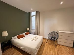 een slaapkamer met een bed met een teddybeer erop bij La Comédie, appart de Charme in Montpellier