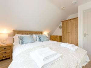 a bedroom with a white bed with two towels on it at The Apple Loft in Mickleton