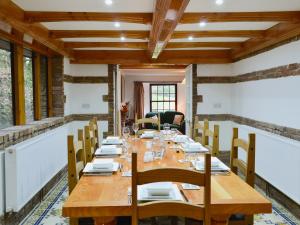 un comedor con una larga mesa de madera y sillas en The Farmhouse - Ukc1339 en North Molton