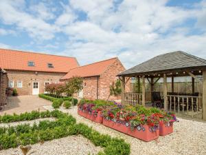 a garden with flowers and a gazebo at Stables in North Somercotes