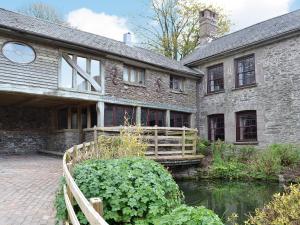 an old stone house with a pond in front of it at The Farmhouse - Ukc1339 in North Molton