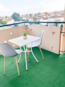 ポーにあるCosy Mûre - 4 CH - Wifi- Parking gratuitのバルコニー(緑の芝生付)にテーブルと椅子