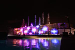 a building with purple lights in front of a fountain at Beppu SUGINOI HOTEL in Beppu