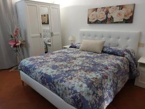 een slaapkamer met een bed met een bloemdekbed bij La Piccola Oasi con parcheggio in Florence