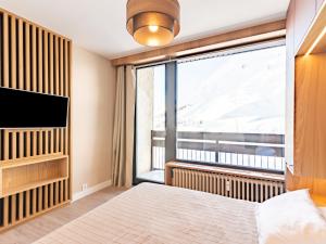 um quarto com uma cama e uma grande janela em Apartment Les Hauts du Val Claret - Val Claret-23 by Interhome em Tignes