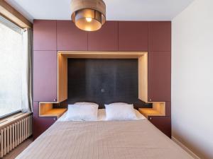 een slaapkamer met een groot bed met paarse muren bij Apartment Les Hauts du Val Claret - Val Claret-23 by Interhome in Tignes