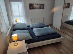 Schlafzimmer mit einem Bett mit blauer Bettwäsche und Kissen in der Unterkunft Ferienwohnung Südpfalz in Weingarten
